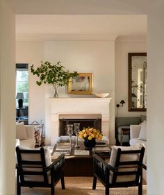 a living room filled with furniture and a fire place under a painting on the wall