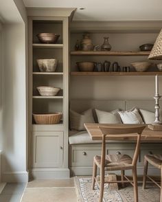 a table and chairs in a room with shelves