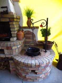 an outdoor brick oven with potted plants on top