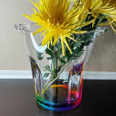 a vase with yellow flowers in it sitting on a table