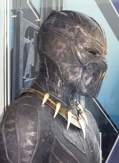 the black panther costume is displayed in front of a glass case with metal spikes on it