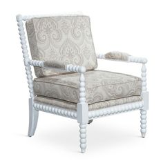 an upholstered chair with white legs and a paisley pattern on the backrest