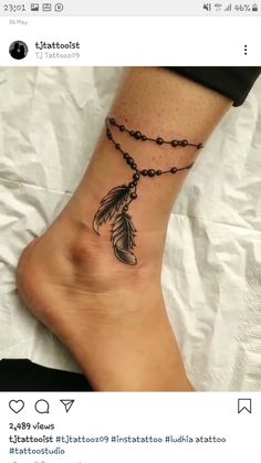 a woman's foot with a tattoo on it that has a feather and beads