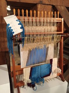 an old weaving machine with blue and white yarn