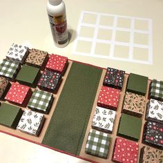 a quilted table runner made out of patchwork squares and plaid fabric, next to a bottle of glue