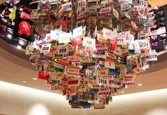 a chandelier made out of license plates hanging from the ceiling in a shopping mall