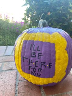 a purple and yellow pumpkin with writing on it