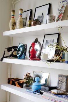 some shelves with pictures and vases on them