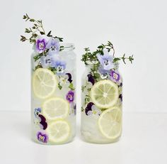 two vases filled with lemon slices and flowers