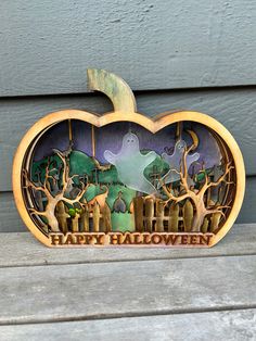 a wooden pumpkin shaped like a halloween scene