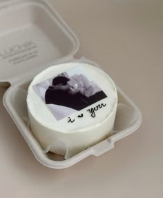 a cake in a plastic container with an image on the side and writing on it