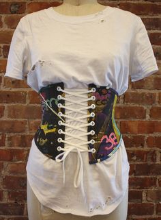 a white t - shirt with a colorful corset attached to it's chest