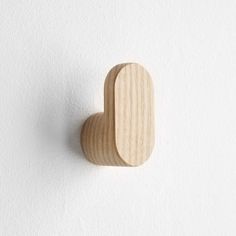 a wooden heart shaped object on a white wall