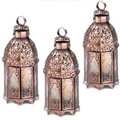 three metal lanterns sitting next to each other