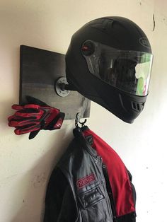 a motorcycle helmet and gloves are hanging on the wall next to a pair of gloves