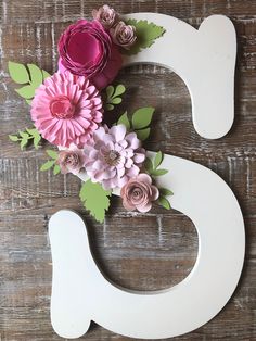 the letter s is decorated with paper flowers and greenery on it's side