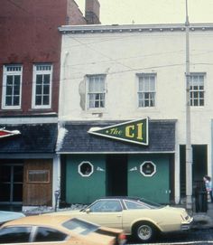 an old photo of cars parked in front of a building