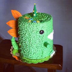 a cake shaped like a green monster with a hat on it's head sitting on a table