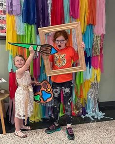 two young children holding up an art piece