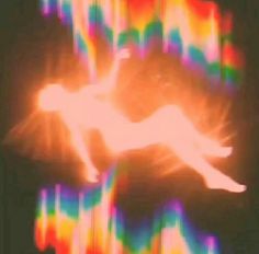 a blurry image of a bird flying in the sky with colored lights behind it