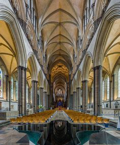 the inside of a cathedral with benches and tables