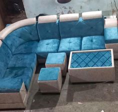 a blue and white sectional couch sitting on top of a floor next to a coffee table