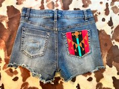 Adorable women's upcycled denim shorts. They feature a faint dip ring on the back left pocket, and a cute western-aztec print on the back right pocket. These shorts are super stretchy and are a womens size 3. They are midrise and have a 2.5 inch inseam. Would be perfect for boho, hippie, or western style. Brand is indigo rein. Festival Cutoff Jean Shorts With Frayed Hem, Western Style Denim Bottoms For Summer, Western Denim Bottoms For Summer, Festival Jean Shorts With Frayed Hem, Western Style Denim Summer Bottoms, Summer Western Denim Bottoms, Bohemian Denim Shorts, Bohemian Denim Shorts For Festivals, Retro Denim Blue Shorts With Pockets