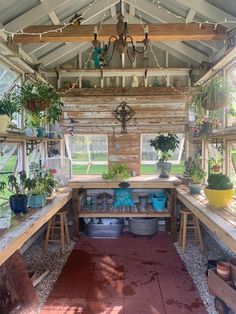 the inside of a greenhouse with potted plants on tables and hanging lights above them