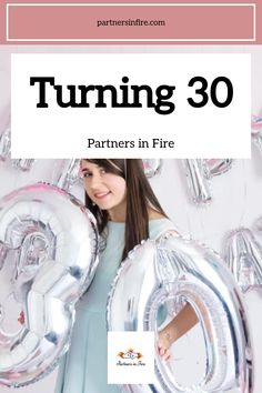 Woman holding large silver balloons forming the number 30, celebrating a birthday.