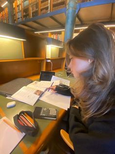 a woman sitting at a table in front of a laptop computer and calculator