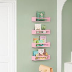 three pink shelves on the wall above a chair