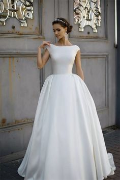 a woman in a white wedding dress posing for the camera