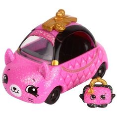 a pink toy car with a gold bow on top and a black cat figurine next to it