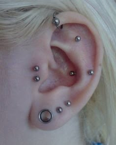 a close up of a person with piercings on their ears and behind the ear