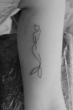 a black and white photo of a woman's arm with a tattoo on it