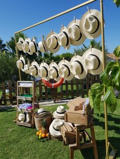 many hats are hanging on a rack in the grass