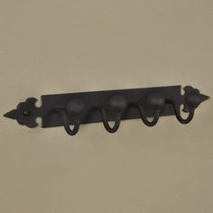 a black coat rack with four hooks on it