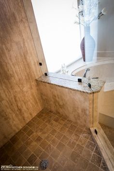 a bath room with a sink and a bath tub next to a window in it