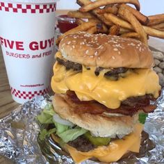 a cheeseburger and fries are sitting on tin foil