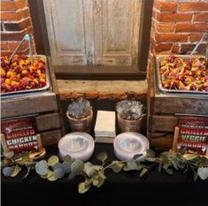 an assortment of food on display in front of a brick wall and wooden shutters