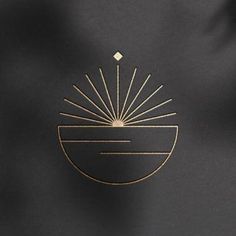 a black and gold bag with the sun in it's center, on a dark background