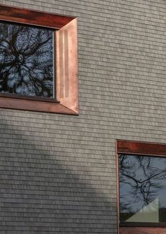 two windows on the side of a brick building