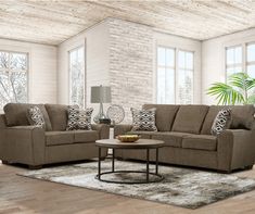 a living room with two couches, a coffee table and a rug on the floor