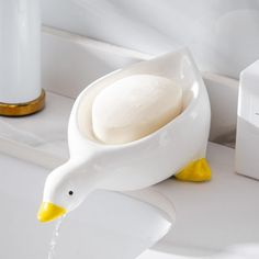 a duck shaped soap dispenser sitting on top of a sink