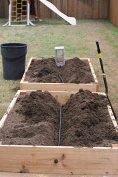 a wooden box filled with dirt next to a yard