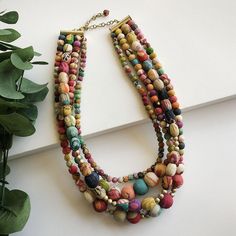 multi - stranded necklace on display next to potted plant