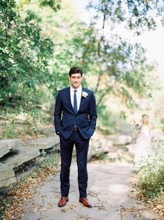 a man in a suit and tie standing on a path