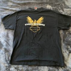 a black harley davidson t - shirt with gold eagle on it