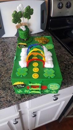 a green cake with white frosting and decorations on the top, sitting on a kitchen counter