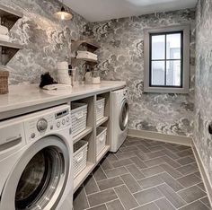 a washer and dryer in a large room with tile flooring on the walls